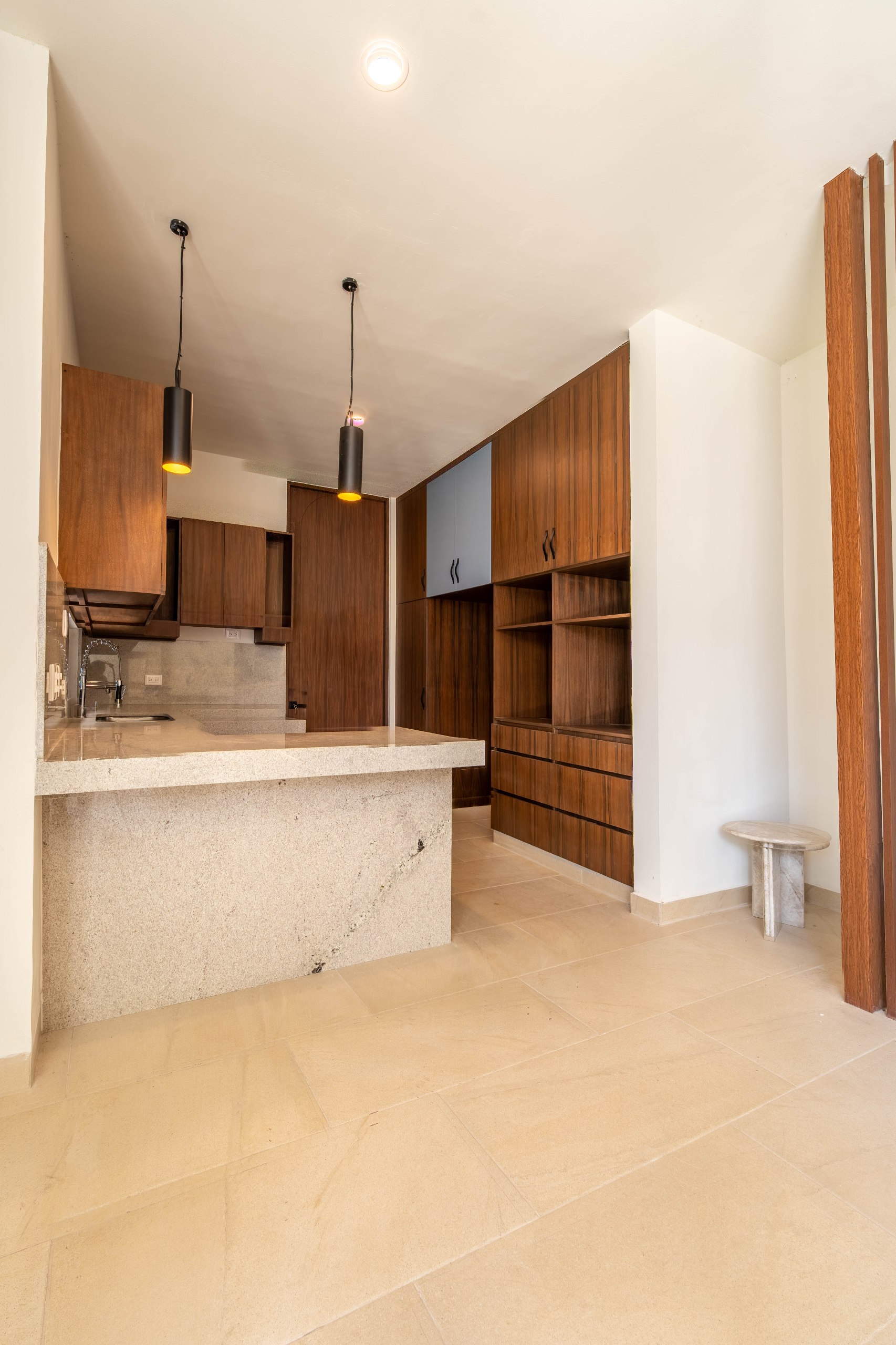 Cocina moderna con gabinetes de madera oscura, encimera de granito y barra desayunadora.